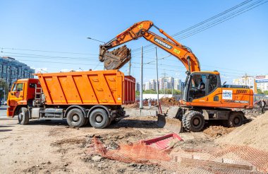 Samara, Rusya - 6 Mayıs 2021: Kazı ve çöp kamyonu yazın bir şantiyede çalışıyor