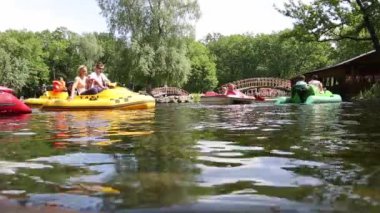 Samara, Rusya - 26 Mayıs 2021: İnsanlar şehir parkındaki gölette pedal veya su katamaranlarına biniyor