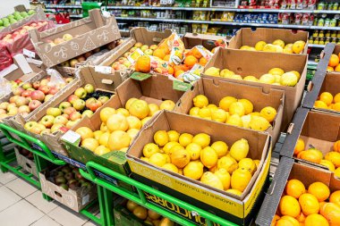 Samara, Rusya - 6 Haziran 2021: Taze elma, limon ve mukavva kutulardaki diğer turunçgiller süpermarkette satılıyor