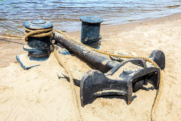 用固定绳和船舶锚在沙滩上的港口系泊护柱 — 图库照片