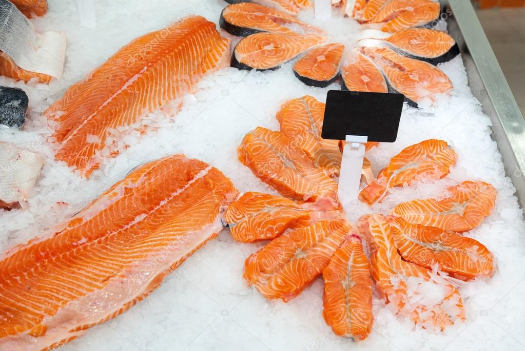 Slices of fresh raw salmon in ice ready to sale at the market