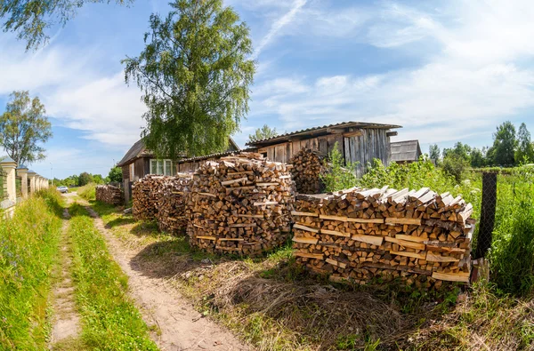 Pila di legna da ardere impilata vicino alla casa rurale — Foto Stock