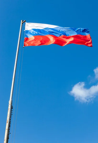 Russische vlag zwaaien in de wind over blauwe hemel — Stockfoto