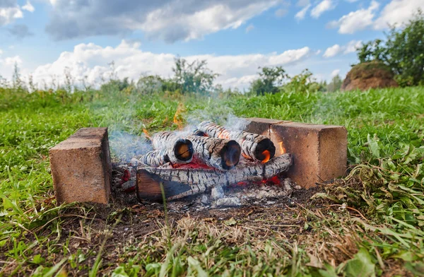 Close-up de fogo quente queimando em uma fogueira ao ar livre — Fotografia de Stock