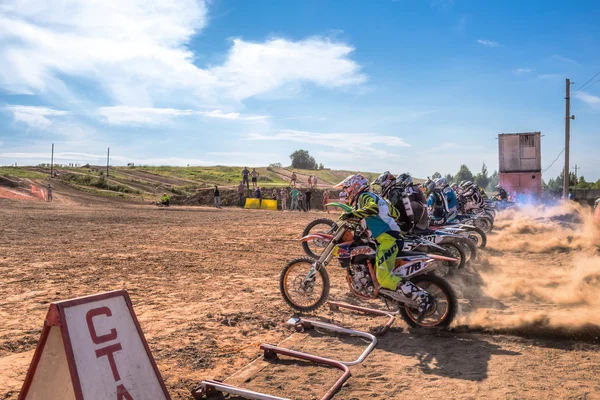 Motocrossers in the starting line waiting for race to start — Stock Photo, Image