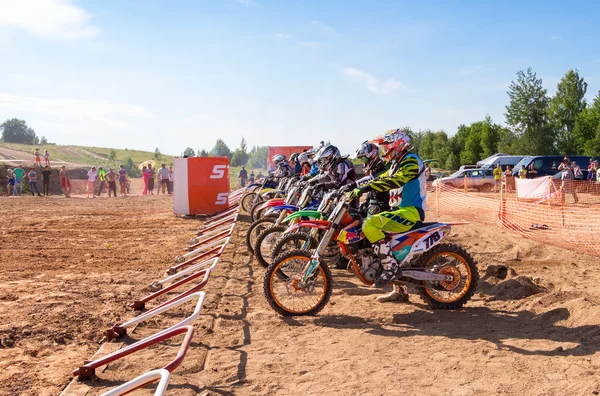 Motocrossers in the starting line waiting for race to start — Stock Photo, Image