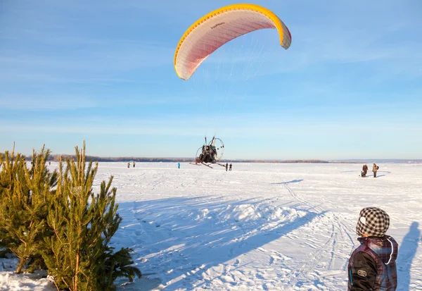 Parapente voador baixo sobre o rio nevado — Fotografia de Stock