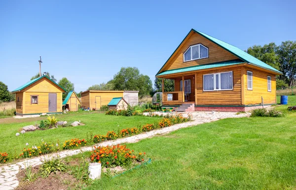 Neues Landhaus aus Holz mit Nebengebäuden im Sommer — Stockfoto