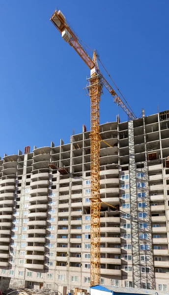 Hohe Mehrfamilienhäuser im Bau mit Kran gegen eine — Stockfoto