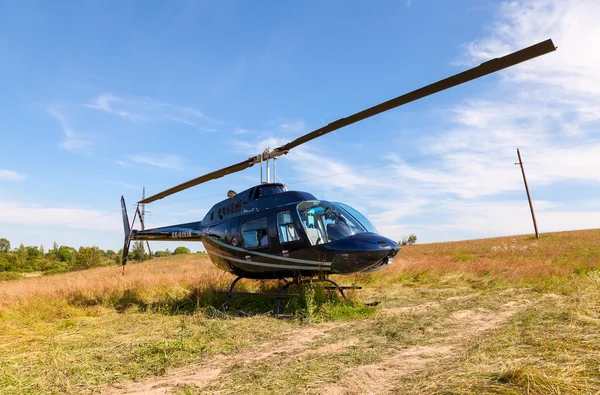 Helicóptero Bell Jet Ranger III de pie en el campo en verano soleado —  Fotos de Stock