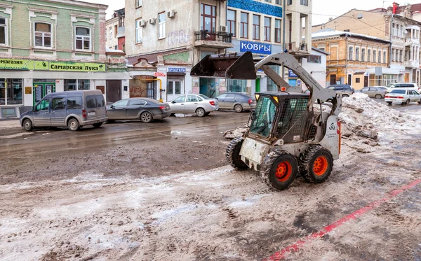 Trator limpar as ruas da cidade de neve e gelo após o — Fotografia de Stock