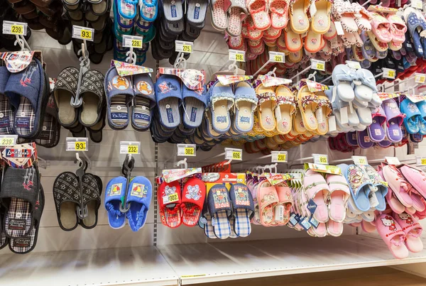 Verschillende slippers klaar voor verkoop op showcase in nieuwe hypermarkt — Stockfoto