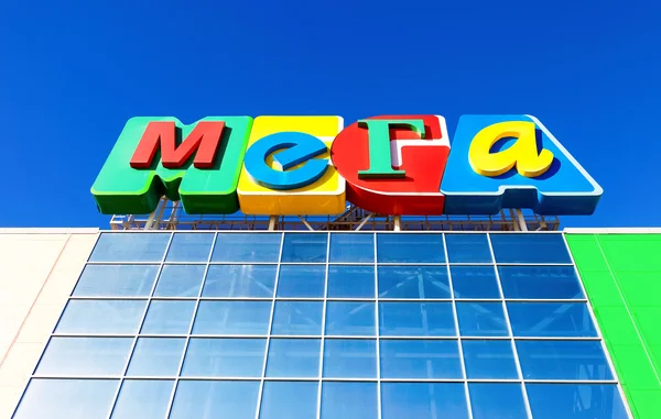 Sign shopping center Mega against the blue sky — Stock Photo, Image