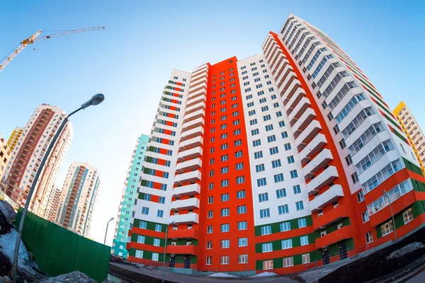Hohe Mehrfamilienhäuser im Bau vor blauem Himmel — Stockfoto