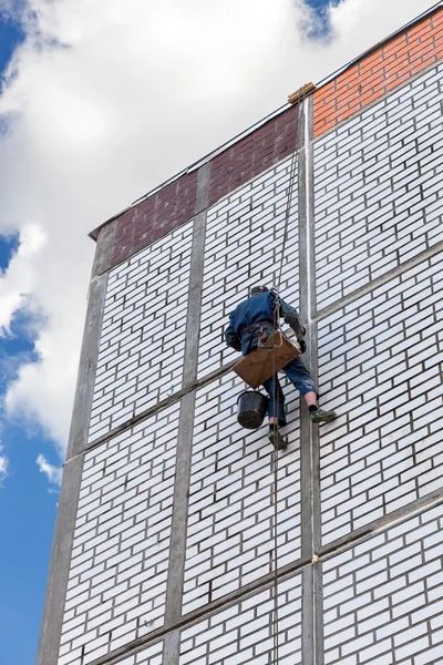 Trabajador de la construcción trabajando en el lado de la casa — Foto de Stock