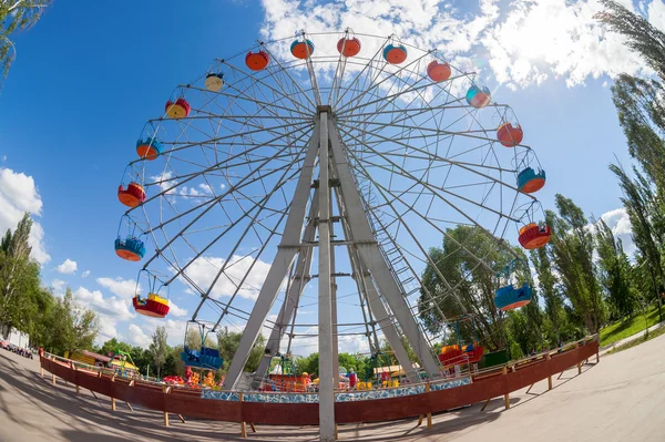 Ruota panoramica sullo sfondo del cielo blu nel parco cittadino — Foto Stock