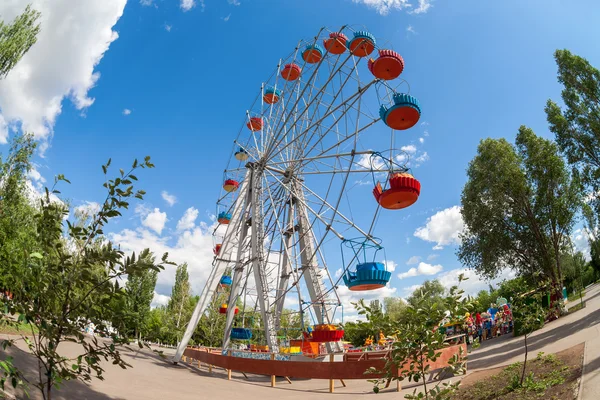 Rueda de la fortuna contra fondo azul del cielo en el parque de la ciudad — Foto de Stock