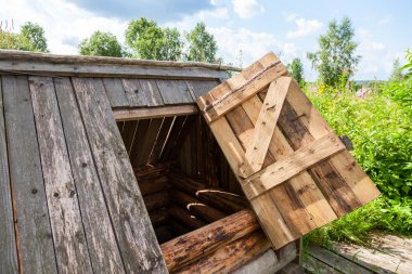 Old village wooden water well in summer day