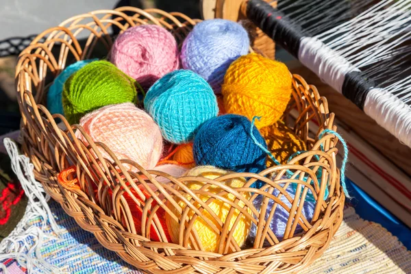 Bright multi-colored balls of yarn in wicker basket — Stock Photo, Image