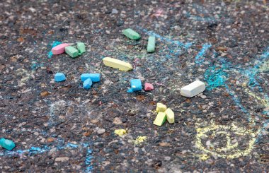 Colorful chalk lie on the asphalt clipart