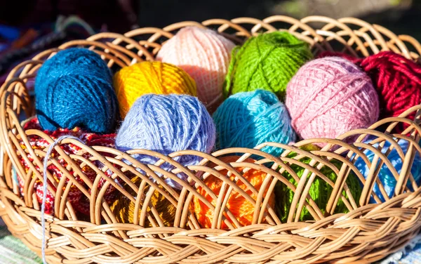 Bright multi-colored balls of yarn in wicker basket — Stock Photo, Image