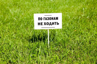 Notice board on the lawn with text on russian: 