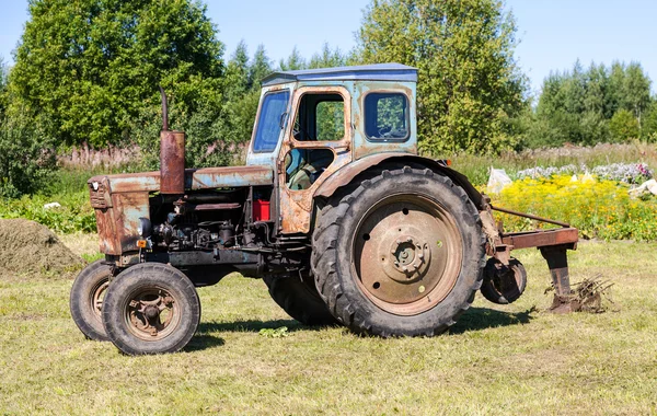 Oude trekker op de Russische dorp in zonnige dag — Stockfoto