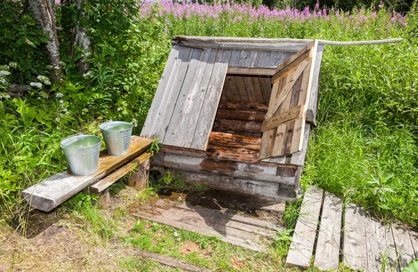 Village wooden water well with the open door and a buckets of wa — Stock Photo, Image