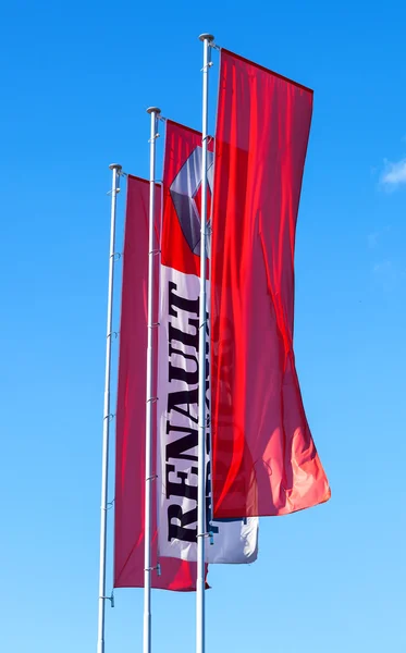 The flags of official dealer Renault over blue sky — Stock Photo, Image