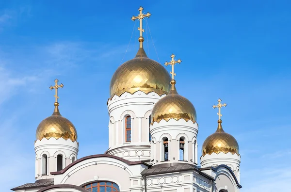 Golden domes of Russian orthodox church with cross against blue — Stock Photo, Image