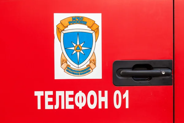 Emblem "Ministry of Emergency Situations of Russia" on the fire — Stock Photo, Image