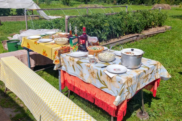 Tavolo da pranzo sdraiato in giardino durante la giornata estiva soleggiata — Foto Stock