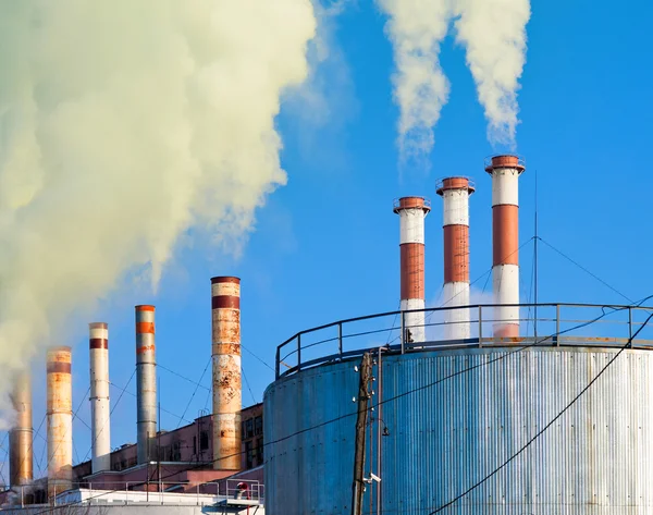 Industrial smoking chimneys against the blue sky Stock Picture