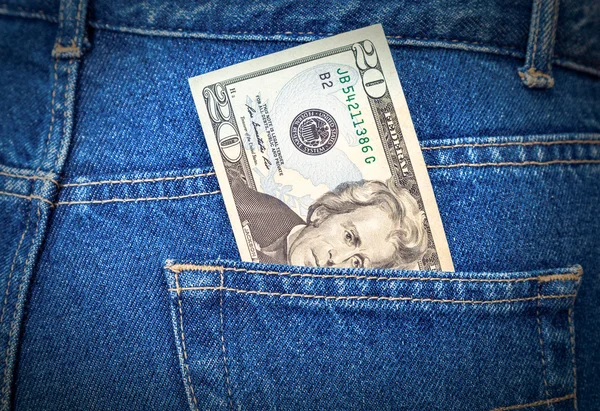 Banknote of twenty dollars sticking out of the blue jeans pocket — Stock Photo, Image