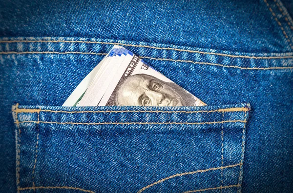 Billetes de dólar doblados que sobresalen del bolsillo de los vaqueros azules — Foto de Stock
