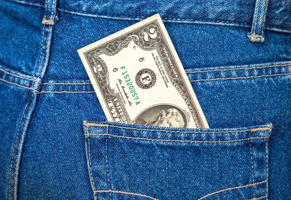 Two dollars bill sticking out of the back jeans pocket — Stock Photo, Image