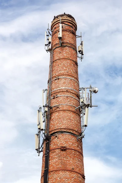 Chaminé de tijolo velho com antenas de comunicação celular — Fotografia de Stock