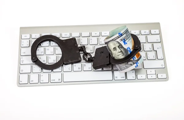 コンピューターのキーボードの上に横たわるスチール手錠とドル法案 — ストック写真