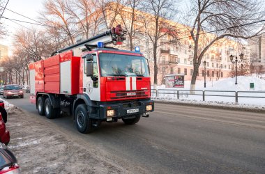 Red firetruck IVECO speeding down a street to a call in Samara,  clipart