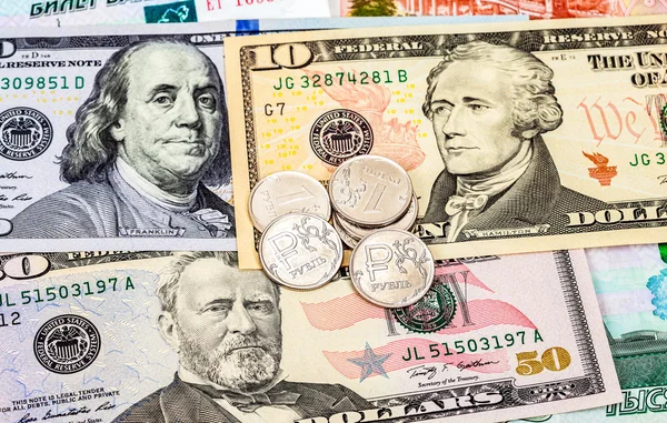Russische roebels munten over dollar biljetten close-up — Stockfoto
