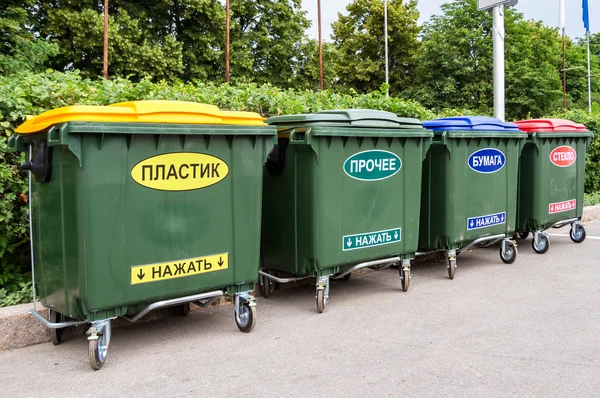 Gröna soptunnor på en stadsgata. Text på ryska: "plast", " — Stockfoto