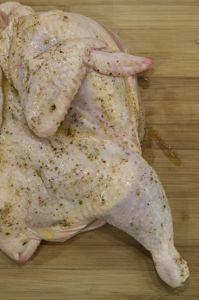 Połowa z surowego kurczaka w przyprawach, gotowe do pieczenia — Zdjęcie stockowe