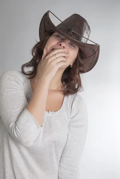 Girl in cowboy hat laughing behind his hand — Stock Photo, Image