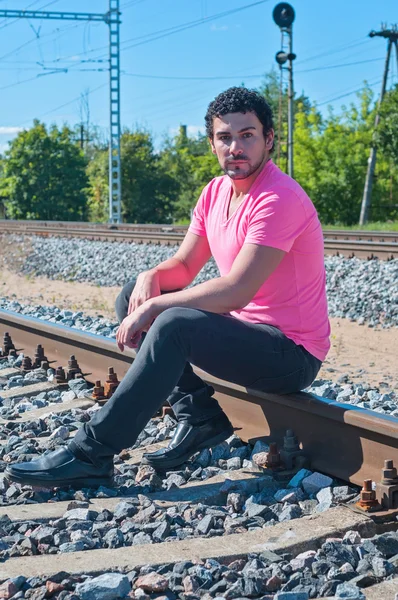 Un hombre de rosa en las vías del tren — Foto de Stock