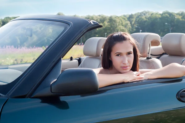 Mooie brunette vrouw zitten in auto — Stockfoto