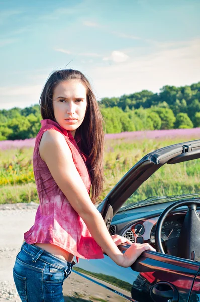 Prachtige brunette vrouwelijke staande in de buurt van auto — Stockfoto