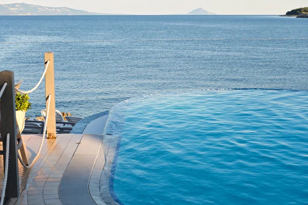 Piscina infinita en la puesta del sol —  Fotos de Stock