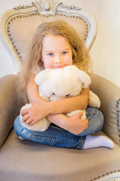 편한 옷을 입고 안락 의자에 앉아 있는 귀여운 소녀 — 스톡 사진