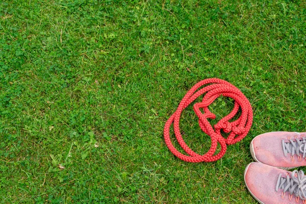 Saltar la cuerda y zapatillas de deporte en el fondo de hierba verde —  Fotos de Stock