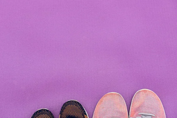 Zapatillas y una esterilla de fitness púrpura. Concepto deportivo —  Fotos de Stock